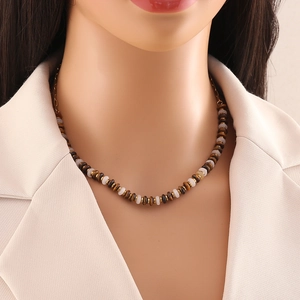 Detail of tiger eye beaded necklace with gold spacers and layered stainless steel clasp