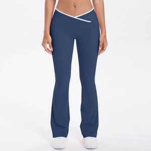 Close-up of crossover V-waistband detail on navy blue flare yoga pants with white trim