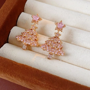 Close-up of pink zircon Christmas tree earrings on brown velvet jewelry display box