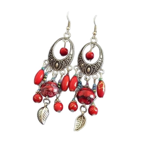 Bohemian silver drop earrings with red beads and leaf fringe on a clean background