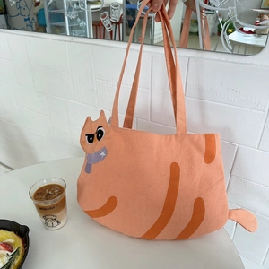 Detail of cute orange cat-shaped canvas tote bag with 3D ears and cartoon face