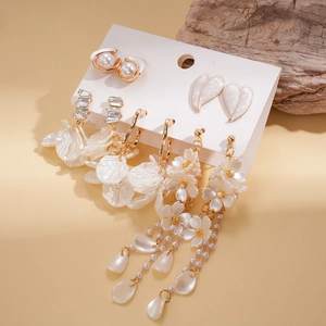 Detail of earring set with shell petals, imitation pearls and crystals on card