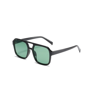 Detail of pilot sunglasses with glossy black double bridge frame and green lenses