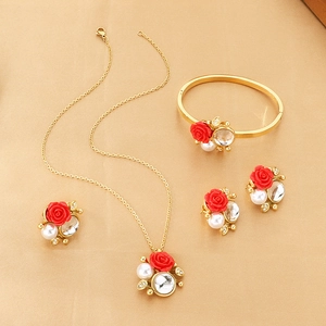 Luxurious gold jewelry set with red rose charms, white pearls and sparkling crystals
