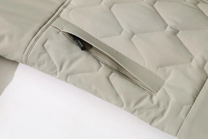 Detailed macro view of quilted khaki winter coat with a fashion zipper pocket design