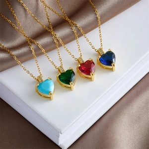Elegant gold-plated heart necklaces with colorful zircon stones on luxury silk background