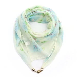 Detail of floral chiffon scarf with golden magnetic buckle and care label closeup