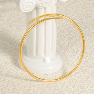 Minimalist 18k gold-plated 304 stainless steel open neck cuff on a decorative column