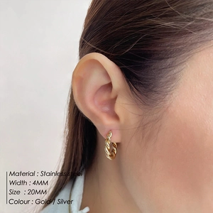 Detailed view of 20mm gold-plated stainless steel twisted hoop earrings on model