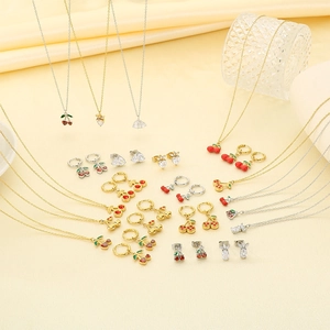 Détail de colliers cerise et fraise sur un fond de tissu beige doux et élégant