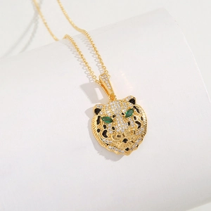 Detailed view of 18K gold plated leopard pendant with emerald eyes and zircon stones