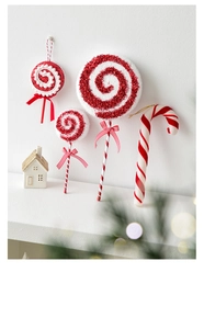 Detail of red and white striped Christmas candy cane ornaments with glitter and bows