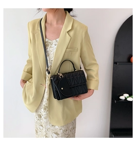 Close-up of black quilted PU leather crossbody bag with top handle and elegant stitching