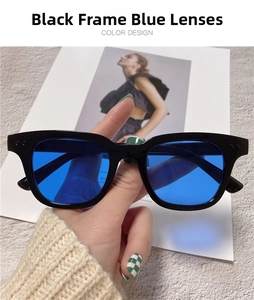 Detail of square black frame sunglasses with vibrant blue lenses and rivet accents