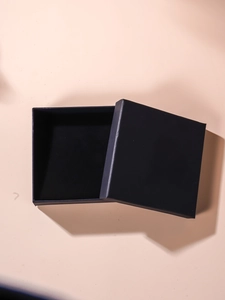 Detail of square navy blue jewelry box with black sponge lining and matte finish