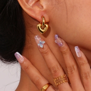 Polished gold heart pendant earrings and textured ring with butterfly nail art style