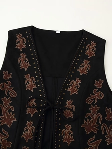 Détails de broderie florale bohème avec des rivets métalliques sur gilet en velours noir