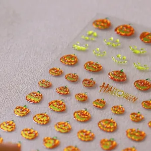 Detailed 3D Halloween nail art stickers with embossed orange pumpkins and green ghosts