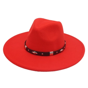 Close-up of wide brim red fedora hat with black leather band and silver diamond metal studs