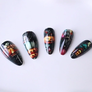Halloween long almond press-on nails featuring pumpkin, skull, and haunted house patterns
