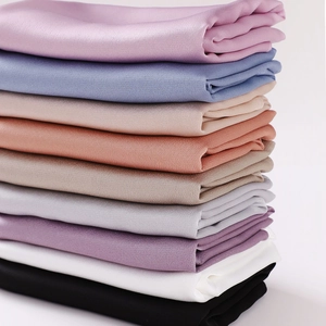 Chiffon silk shawls in multiple colors stacked neatly on a clean white background
