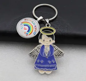 Detail view of Schulkind metal keychain with praying angel charm and rainbow pendant charm