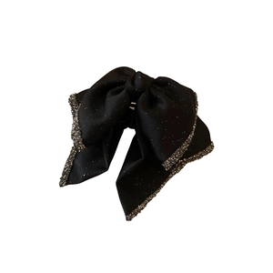 Elegant black bow hair claw clip with shimmering rhinestones on white background