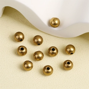 Vintage bronze brass spacer beads for DIY jewelry making on textured background