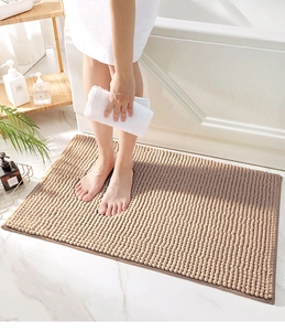 Close-up of soft khaki chenille bath mat with feet showing plush anti-slip texture