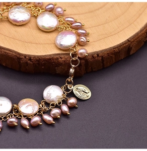 Detailed macro view of baroque pearls and a golden Virgin Mary pendant on this bracelet