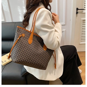 Detail view of large brown vintage pattern tote bag styled with a white blazer outfit