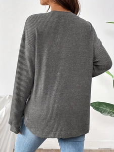 Detail of dark grey ribbed maternity top showing texture and long sleeve design
