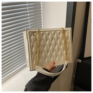 Detail of white quilted texture leather bag with elegant golden metal chain strap