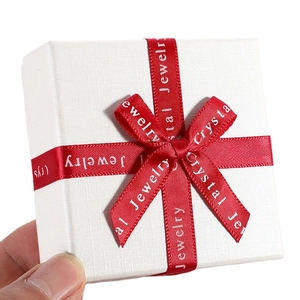 Square white jewelry gift box with textured finish and red Crystal Jewelry ribbon bow