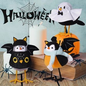 Trois oiseaux en tissu d'Halloween avec thèmes de chauve-souris et fantôme sur table