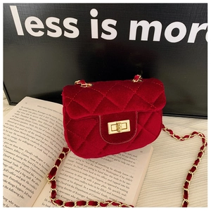 Gros plan sur un mini sac bandoulière en velours rouge avec matelassage en losange
