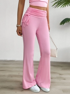 Détail du pantalon évasé rose avec taille haute à cordon et design froncé sur le côté