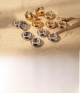 Macro shot of titanium steel ear cuffs with hammered and smooth texture in gold and steel