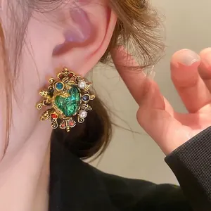 Baroque emerald crown earrings with pearls and vintage gold metal on female model