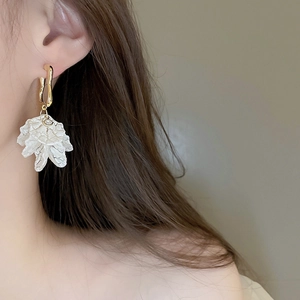 Detail of sweet acrylic pleated flower earrings with gold plating and small rhinestone