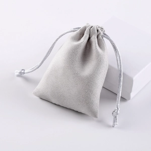 Grey microfiber jewelry drawstring pouch with silver cord and white gift box