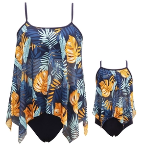 Matching mother and daughter tankini swimsuits with tropical leaf print in navy blue