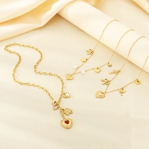 Close-up of golden multi-layer necklaces with clover, heart and bow charms on satin