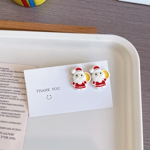 Détail de boucles d'oreilles Père Noël rouges avec finition émail sur carte de présentation