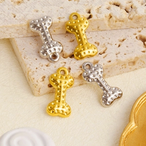 Close-up of 304 stainless steel bone-shaped charms in gold and silver with dot textures
