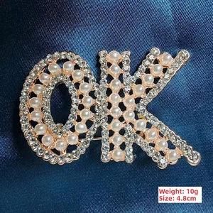 Detailed view of OK letter brooch with white pearls and rhinestones 4.8cm size