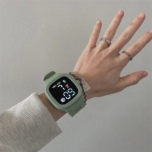 Close-up of a green LED sports watch on wrist showing time and heart rate display