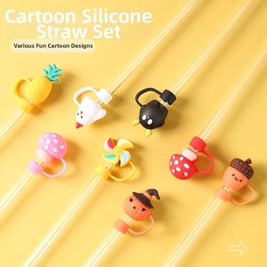 Close-up of various cartoon silicone straw toppers including pineapple and pumpkin shapes