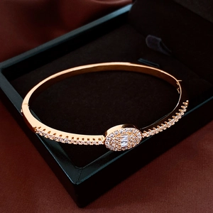 Detail of 18K gold plated oval bangle with pavé zircons in a luxury black jewelry box