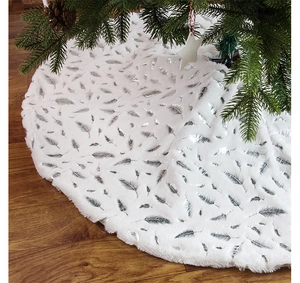 Detail of white plush Christmas tree skirt with shiny silver foil feather patterns